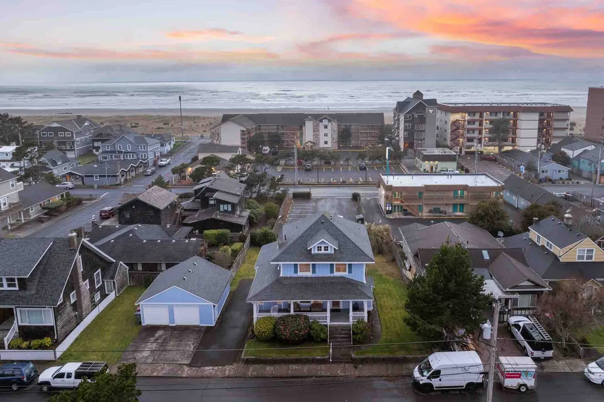 A relaxed ocean view at sunset, with vibrant colors in the sky and the nearby neighborhood houses visible. The scene captures the close-knit feel of the community and the easy access from home to beach, with tranquil waves and a peaceful atmosphere.