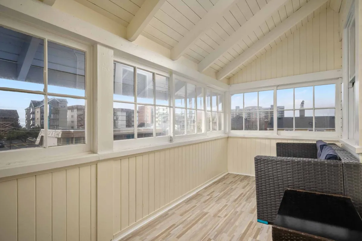 A cozy interior seating area with large windows, inviting natural light and offering a serene spot to relax, read, or simply enjoy the ambiance of a rainy day indoors. The space is designed for comfort, making it ideal for family bonding and indoor fun.